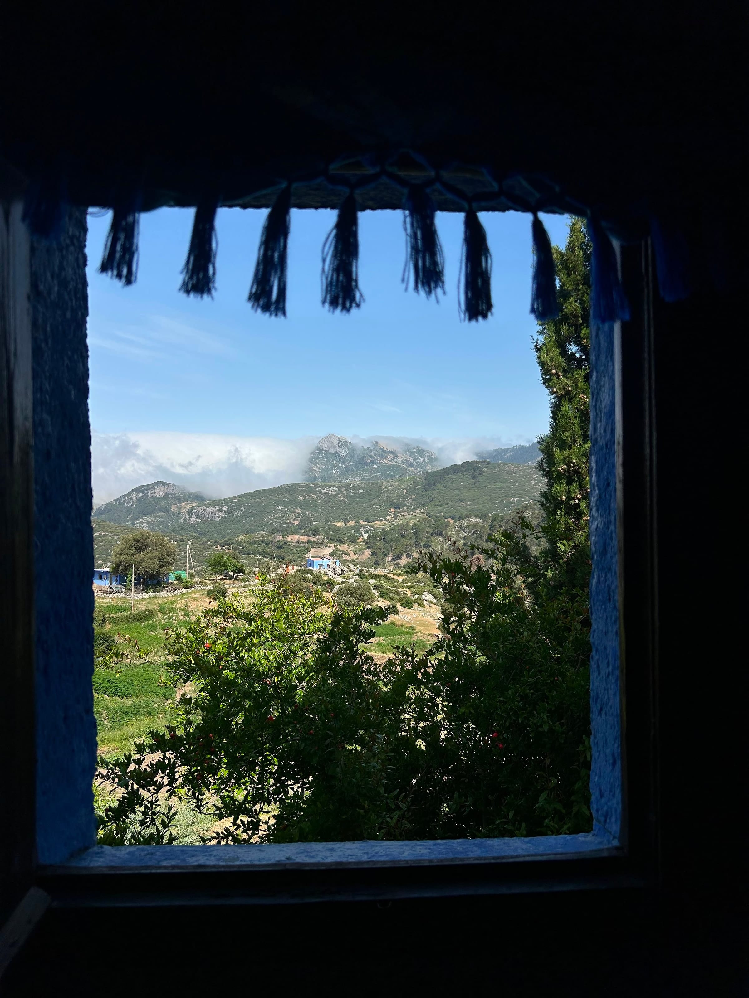 Le montagne viste dalla finestra blu di una casa di Chefchaouen